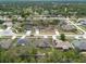 An aerial perspective of residences featuring manicured lawns, tree-lined streets, and solar panels on several rooftops at 3642 Fantasy Way, Brooksville, FL 34604