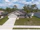 Aerial view of a home with solar panels, two-car garage, a well-manicured lawn, and a paved driveway at 3642 Fantasy Way, Brooksville, FL 34604