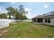 A view of the expansive, green backyard, complete with a white fence and solar panels at 3642 Fantasy Way, Brooksville, FL 34604
