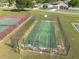 Aerial view of a fenced community basketball court beside the tennis court in a beautifully maintained neighborhood at 3642 Fantasy Way, Brooksville, FL 34604