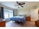 Comfortable bedroom featuring a ceiling fan, window with natural light and wood-look floors at 3642 Fantasy Way, Brooksville, FL 34604