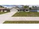 Attractive home with a well-maintained lawn, complemented by a two-car garage and a welcoming front porch at 3642 Fantasy Way, Brooksville, FL 34604