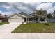 Inviting home exterior with a well-kept lawn, solar panels, and a neat two-car garage at 3642 Fantasy Way, Brooksville, FL 34604