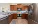 Well-lit kitchen featuring stainless steel appliances, wood cabinets and countertop space at 3642 Fantasy Way, Brooksville, FL 34604