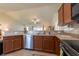 Kitchen featuring stainless steel appliances, wood cabinets, and breakfast bar overlooking the living area at 3642 Fantasy Way, Brooksville, FL 34604