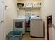 Laundry room with washer, dryer, storage shelves, and a blue laundry basket at 3642 Fantasy Way, Brooksville, FL 34604