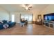 Bright living room with ceiling fan, wood floors, comfortable seating, and large windows at 3642 Fantasy Way, Brooksville, FL 34604