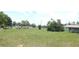 Vast backyard with a mix of open green space and mature trees, offering privacy and room for outdoor activities at 38535 Clinton Ave, Dade City, FL 33525
