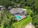 Aerial view of the property featuring a screened pool, well-manicured lawn, and mature trees at 3910 Saywood Ct, Palm Harbor, FL 34685