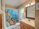 Cozy bathroom with a unique fish-themed shower curtain and wooden vanity at 3910 Saywood Ct, Palm Harbor, FL 34685