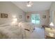 Bright bedroom featuring twin beds with patterned bedspreads, a large window, and light colored walls and carpet at 3910 Saywood Ct, Palm Harbor, FL 34685