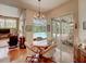 Elegant dining area near pool entrance, featuring stylish furniture, chandelier and view of the screened pool area at 3910 Saywood Ct, Palm Harbor, FL 34685