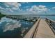 Picturesque view of the dock stretching out into the serene lake, reflecting the sky above at 3910 Saywood Ct, Palm Harbor, FL 34685