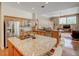 Open kitchen with granite countertops, wood cabinets, stainless steel appliances and adjacent living area at 3910 Saywood Ct, Palm Harbor, FL 34685