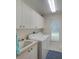 Clean laundry room with white washer, dryer, sink and ample cabinet space at 3910 Saywood Ct, Palm Harbor, FL 34685