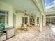 Covered outdoor patio with brick flooring, ceiling fans, and views of the pool and lush landscaping at 3910 Saywood Ct, Palm Harbor, FL 34685
