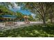 Shaded playground featuring picnic tables, play structures, and swings at 3910 Saywood Ct, Palm Harbor, FL 34685