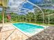 Serene screened-in pool and spa with brick paver deck overlooking a pond at 3910 Saywood Ct, Palm Harbor, FL 34685