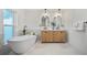 Luxurious bathroom with a freestanding tub, double vanities, and elegant lighting at 3925 Dunaire Dr, Valrico, FL 33596