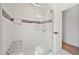 Modern shower is tiled with a glass door, bench, and accent tile; a luxurious bathroom at 3925 Dunaire Dr, Valrico, FL 33596