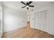 Relaxing bedroom has wood floors, white walls, a ceiling fan, and closet doors at 3925 Dunaire Dr, Valrico, FL 33596