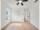 Bright bedroom features light wood floors, white walls, a ceiling fan, and a window for natural light at 3925 Dunaire Dr, Valrico, FL 33596