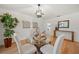 Dining area features wood floors, glass table, chairs, light fixture, and a large plant at 3925 Dunaire Dr, Valrico, FL 33596