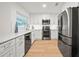 Modern kitchen featuring white cabinets, stainless steel appliances, and light wood flooring at 3925 Dunaire Dr, Valrico, FL 33596