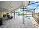 Screened in pool and patio has pavers, a water view, ceiling fans, and plenty of space for entertaining at 3925 Dunaire Dr, Valrico, FL 33596