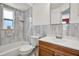 Bright bathroom featuring a vanity, mirror, bathtub, toilet, and tiled walls at 4307 Shadberry Dr, Tampa, FL 33624