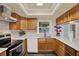 A bright kitchen featuring stainless steel appliances, wood cabinetry, white countertops, and ample counter space at 4307 Shadberry Dr, Tampa, FL 33624