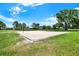 Well-maintained outdoor sand volleyball court surrounded by lush green grass under a bright blue sky at 4307 Shadberry Dr, Tampa, FL 33624