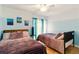 Bright bedroom with two beds, natural light, and mountain-themed paintings at 4419 Longshore Dr, Land O Lakes, FL 34639