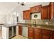 An open kitchen with granite countertops, a wine fridge, stainless steel appliances and dark wood cabinets at 4419 Longshore Dr, Land O Lakes, FL 34639