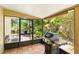 Screened-in patio with a grill, overlooking the backyard at 4419 Longshore Dr, Land O Lakes, FL 34639