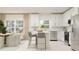 Open concept kitchen with stainless steel appliances, white cabinets, and a breakfast bar with modern stools at 4511 S Manhattan Ave # 3, Tampa, FL 33611