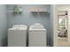 This efficient laundry room features a front load washer and dryer and a shelf with decorative baskets at 4511 S Manhattan Ave # 3, Tampa, FL 33611