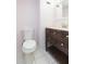 Bathroom features a dark wood vanity, toilet, and white tile floor at 4517 La Capri Ct, Tampa, FL 33611
