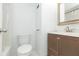 This bathroom includes a toilet, vanity, mirror and shower with white walls and tile floors at 4517 La Capri Ct, Tampa, FL 33611