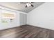 This spacious bedroom features dark wood floors, a ceiling fan and natural light from a large window at 4517 La Capri Ct, Tampa, FL 33611