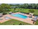 Aerial view of community pool with lounge chairs, a hot tub and nearby amenities at 4517 La Capri Ct, Tampa, FL 33611