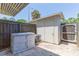 Exterior shed in backyard featuring a white door, storage bin and air conditioner at 4517 La Capri Ct, Tampa, FL 33611