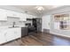 Kitchen with black appliances, white cabinetry, gray walls and laminate flooring at 4517 La Capri Ct, Tampa, FL 33611