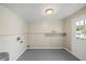Utility room with grey painted floor and door to the backyard at 4804 N 18Th St, Tampa, FL 33610