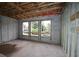 Spacious unfinished living room featuring large windows, block walls, and construction grade flooring at 503 W Warren Ave # 1, Tampa, FL 33624