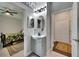 A bathroom with a vanity and an oval mirror sits between a bedroom and a closet at 5057 Ivory Stone Dr, Wimauma, FL 33598