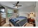 Comfortable bedroom with large windows, ceiling fan and a plush bed at 5057 Ivory Stone Dr, Wimauma, FL 33598
