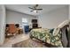 Bedroom with a floral comforter, ceiling fan, and a desk area with computer at 5057 Ivory Stone Dr, Wimauma, FL 33598