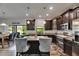 A kitchen with dark cabinetry, stainless steel appliances, and a granite-topped island at 5057 Ivory Stone Dr, Wimauma, FL 33598