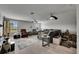 Spacious living room with neutral colors, multiple seating areas, and two ceiling fans at 5057 Ivory Stone Dr, Wimauma, FL 33598